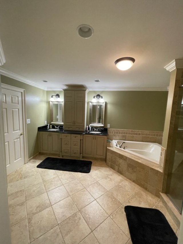 A dated bathroom with olive walls, before a refresh