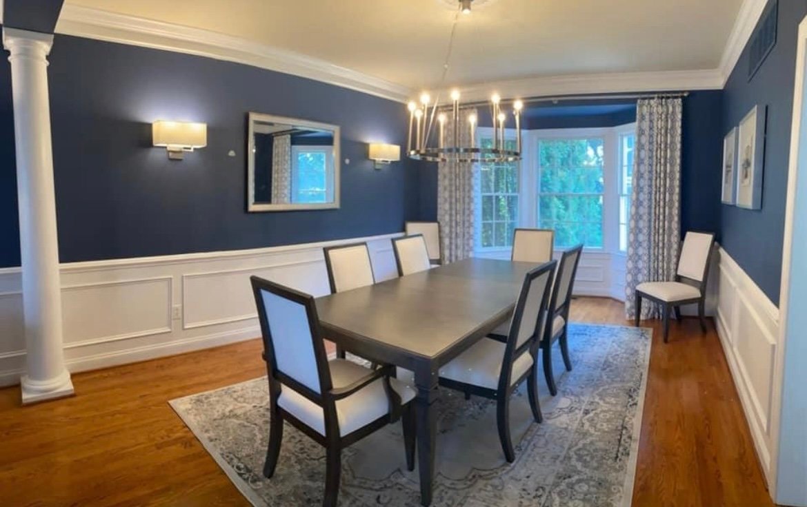 Formal dining room with navy walls and white wainscoting